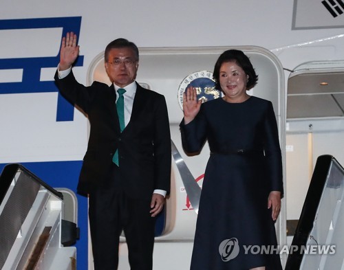 当地时间10月18日，韩国总统文在寅（左）与夫人金正淑乘专机抵达比利时布鲁塞尔，向接机人士挥手致意。（韩联社）