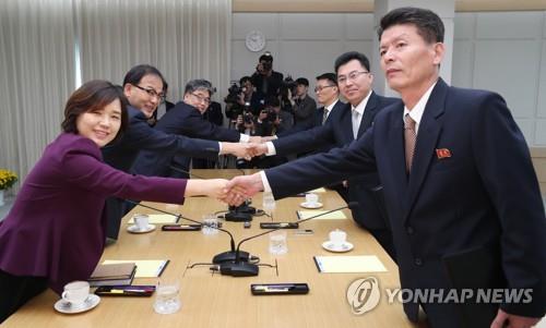 10月22日，在开城工业园区内的韩朝联办，韩朝山林合作会谈双方代表团成员在开会前握手合影。左排为韩方。（韩联社/联合采访团）