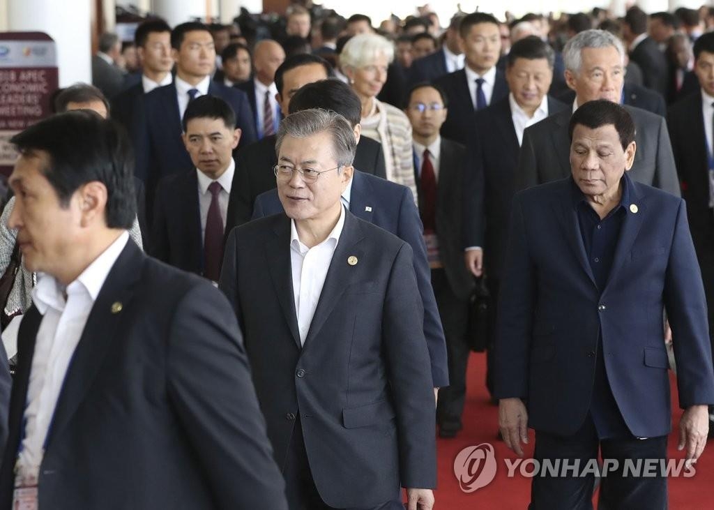 当地时间11月18日，韩国总统文在寅（左二）步入巴新APEC峰会场。（韩联社）