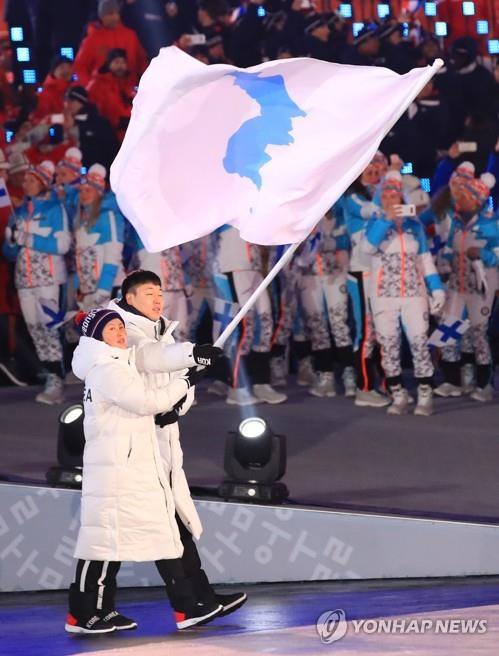 资料图片:在江原道平昌奥林匹克体育场举行的2018平昌冬奥会开幕式上,韩朝代表团举半岛旗共同入场。(韩联社)