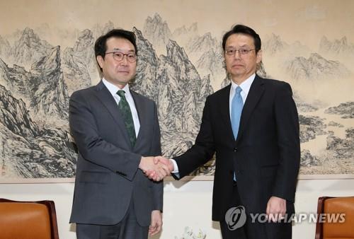 资料图片：4月23日，在首尔韩国外交部大楼，朝核六方会谈韩方团长李度勋（左）和日方团长金杉宪治握手合影。（韩联社）