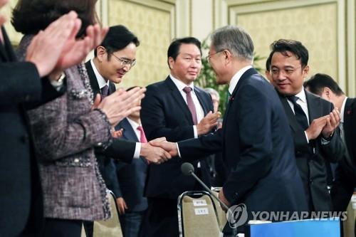 1月15日，在青瓦台，韩国总统文在寅（前排左一）出席韩国大中型企业代表座谈并同与会企业家握手。（韩联社）