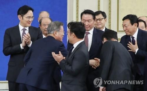 1月15日，在青瓦台，韩国总统文在寅（前排右）出席韩国大中型企业代表座谈并同与会企业家握手。（韩联社）