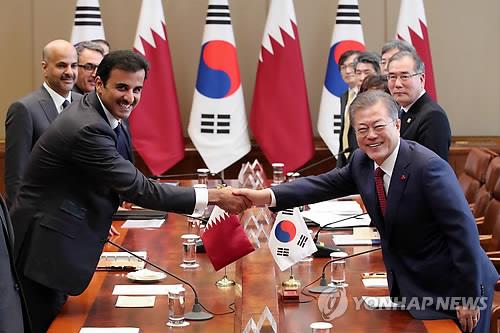 1月28日，在青瓦台，韩国总统文在寅（右）同卡塔尔国埃米尔塔米姆·本·哈马德·阿勒萨尼握手合影。（韩联社）
