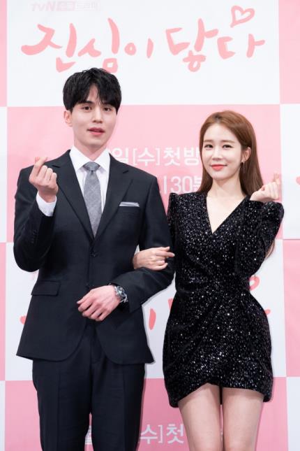 1月29日，在首尔皇宫酒店举行的《触及真心》发布会上，李栋旭和刘仁娜摆姿势供媒体拍照。（tvN供图）