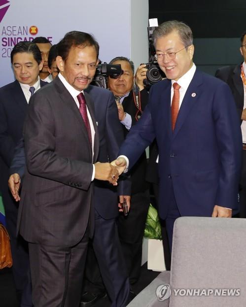 资料图片：2018年11月14日，在新加坡，韩国总统文在寅（右）同文莱国家元首苏丹博尔基亚握手合影。（韩联社）