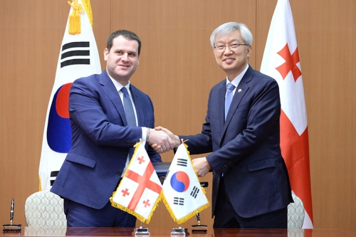 3月11日，在位于首尔的外交部办公楼，李泰镐（右）与盖纳迪·阿维拉泽在签署经贸合作协议后握手合影。（韩联社/外交部供图）