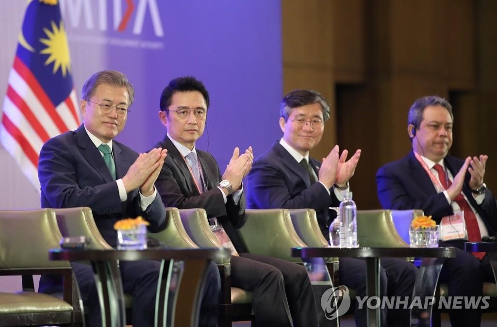 3月14日，在马来西亚吉隆坡，韩国总统文在寅（左一）出席韩马商务论坛。（韩联社）
