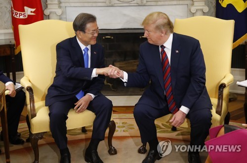 资料图片：当地时间4月11日下午，在美国白宫，韩国总统文在寅（左）和美国总统特朗普在单独会谈开始前握手。（韩联社）