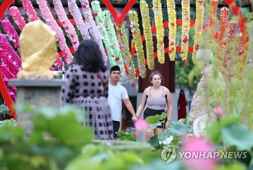 资料图片：7月10日，在位于首尔钟路区的曹溪寺，外国游客欣赏莲花。 韩联社