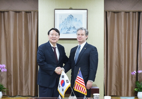 9月24日，美国联邦调查局（FBI）局长克里斯托弗·雷（右）与韩国检察总长尹锡悦举行会谈前握手合影。 韩联社/大检察厅供图（图片严禁转载复制）