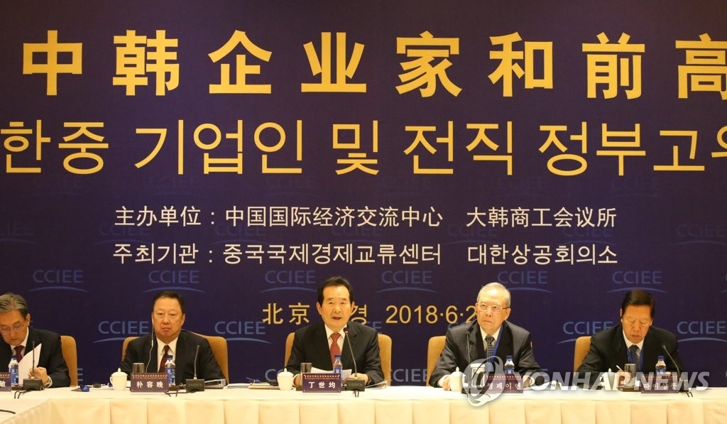 资料图片：2018年6月29日上午，在北京，韩国前国会议长丁世均（中）在首轮韩中企业家和前高官对话上致辞。韩联社