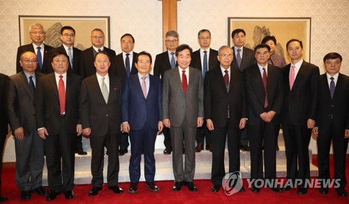 资料图片：12月4日，在位于首尔三清洞的总理公馆，韩国总统李洛渊（前排左五）与出席第二轮韩中企业家和前高官对话会的双方代表合影。 韩联社