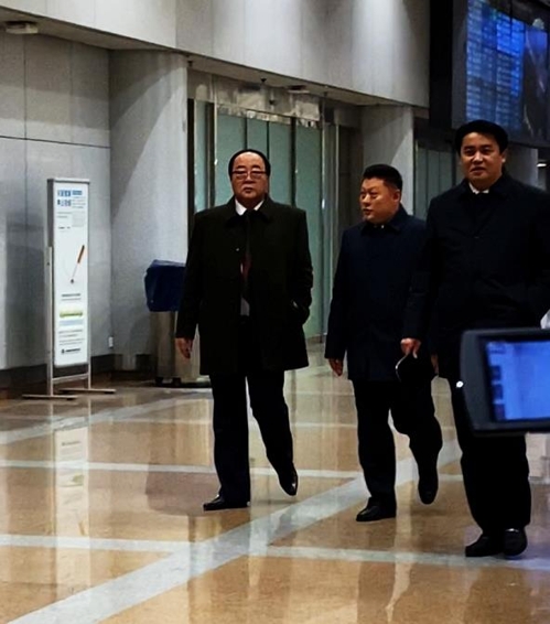 当地时间12月5日，在北京首都国际机场，朝鲜对外经济相金英才（左一）下机后前往乘车地点。 韩联社
