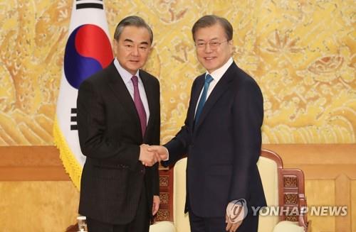 12月5日下午，在青瓦台，韩国总统文在寅（右）会见到访的中国国务委员兼外交部长王毅。 韩联社