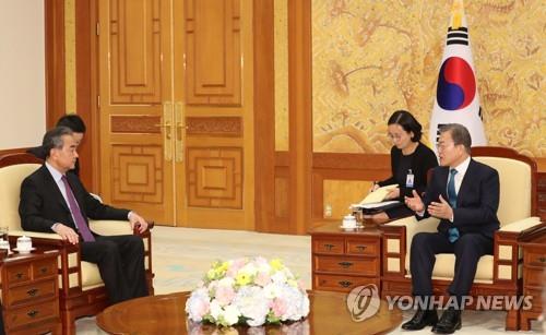 12月5日下午，在青瓦台，韩国总统文在寅（右）会见到访的中国国务委员兼外交部长王毅。 韩联社