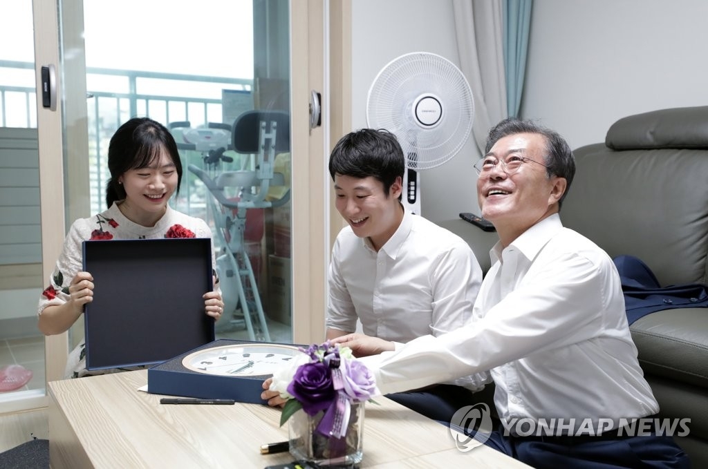 资料图片：韩国总统文在寅（右一）走访公租房关切民生。 韩联社