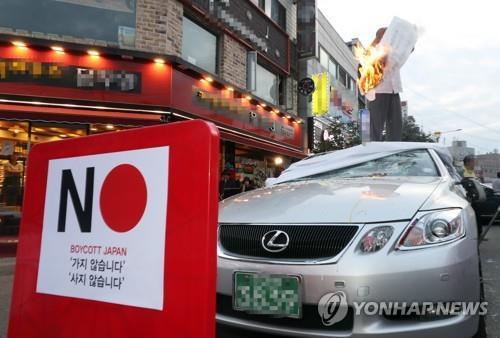 资料图片：7月23日，在仁川市进行的一次示威上，参加者演示砸破一辆雷克萨斯。 韩联社