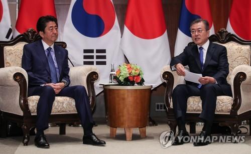 资料图片：当地时间2018年9月25日，在纽约，韩国总统文在寅（右）会见日本首相安倍晋三。 韩联社