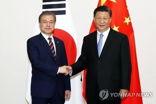 资料图片：2019年6月27日，在日本大阪，韩国总统文在寅（左）同中国国家主席习近平握手合影。 韩联社