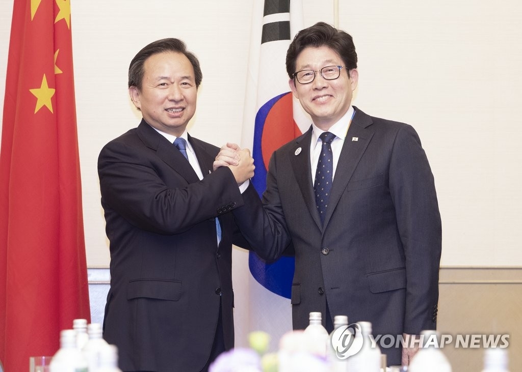 资料图片：11月23日，在日本北九州，韩国环境部长官赵明来（右）与中国生态环境部部长李干杰在会谈上合影。 韩联社