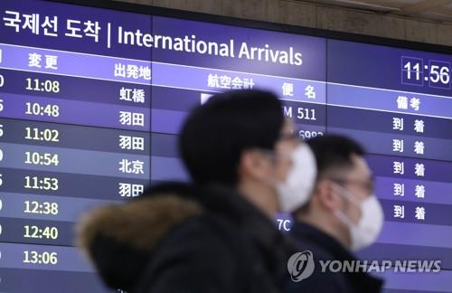 1月28日，在金浦国际机场，来自北京和上海等地的旅客戴口罩抵韩。 韩联社