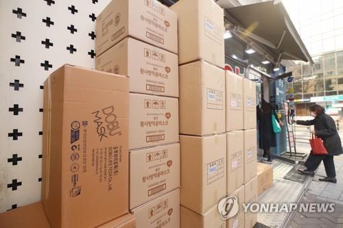 资料图片：首尔一家药店前堆积着多箱口罩。 韩联社