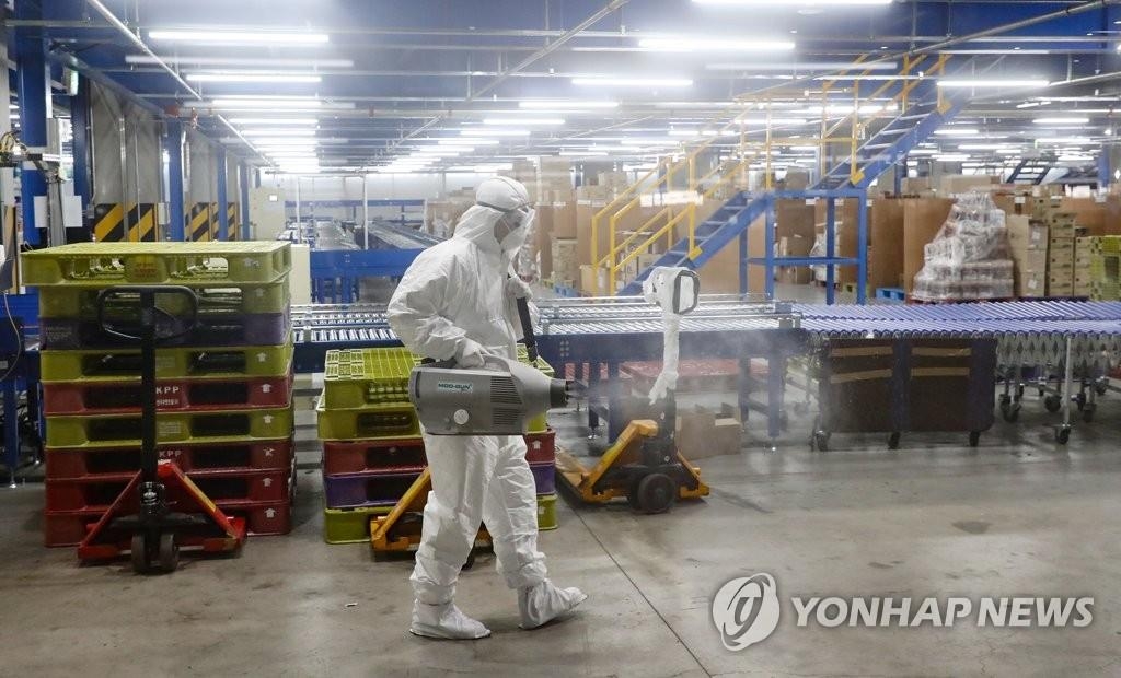 资料图片：防疫工作人员对物流中心进行消毒。 韩联社