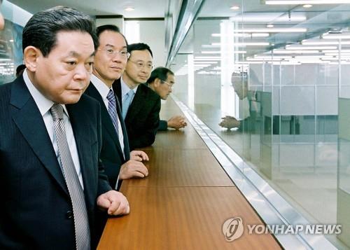 资料图片：2003年10月10日，在位于京畿道华城的三星电子存储器研究楼，李健熙（左一）听取有关下一代存储器的介绍。 韩联社