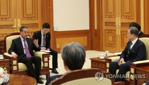资料图片：2019年12月5日下午，在青瓦台，韩国总统文在寅（右）接见到访的中国国务委员兼外交部长王毅。 韩联社