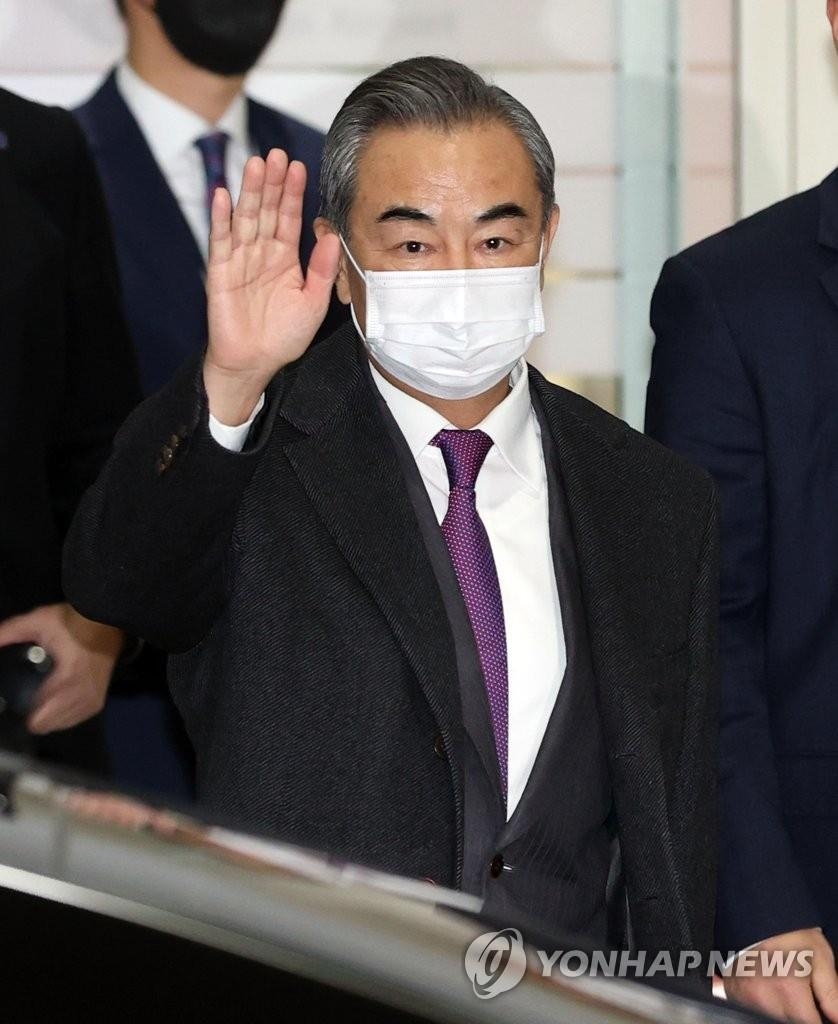 11月25日，在仁川国际机场，中国国务委员兼外交部长王毅向韩国记者挥手致意。 韩联社