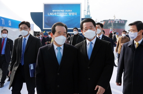 12月11日,韩国国务总理丁世均(中)和全罗南道道知事金瑛录(右二)出席18万吨级液化天然气(LNG)动力远洋船“HL ECO”号和“HL GREEN”号的接船暨命名仪式。 韩联社/全罗南道政府供图(图片严禁转载复制)