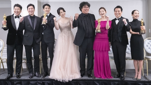 资料图片：2月10日，《寄生虫》导演奉俊昊（中）和演员们获得奥斯卡金奖后合影留念。 韩联社