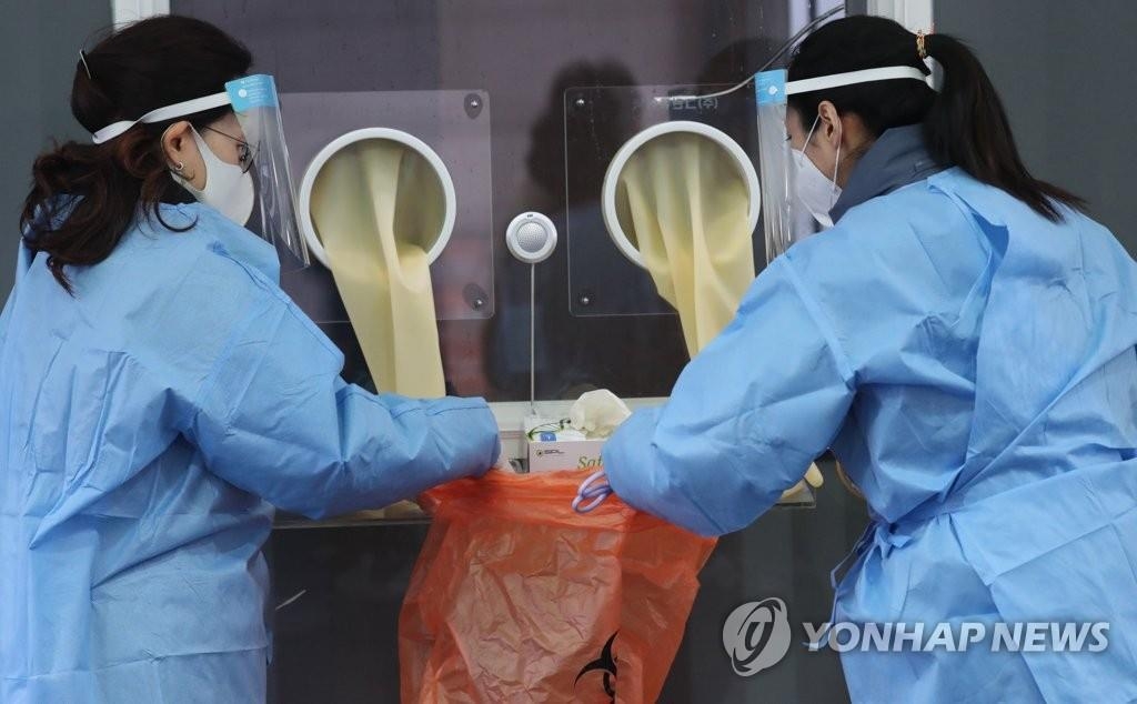 资料图片：1月26日上午，在设于首尔火车站广场的临时筛查诊所，医务人员正为开展新冠病毒检测做准备。 韩联社