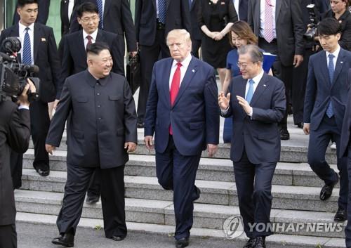 资料图片：2019年6月30日，朝鲜国务委员会委员长金正恩（左）、美国时任总统特朗普（中）和韩国总统文在寅（右）在板门店会晤。 韩联社