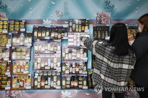 资料图片：1月24日，在首尔一家超市，顾客在挑选春节礼盒。 韩联社