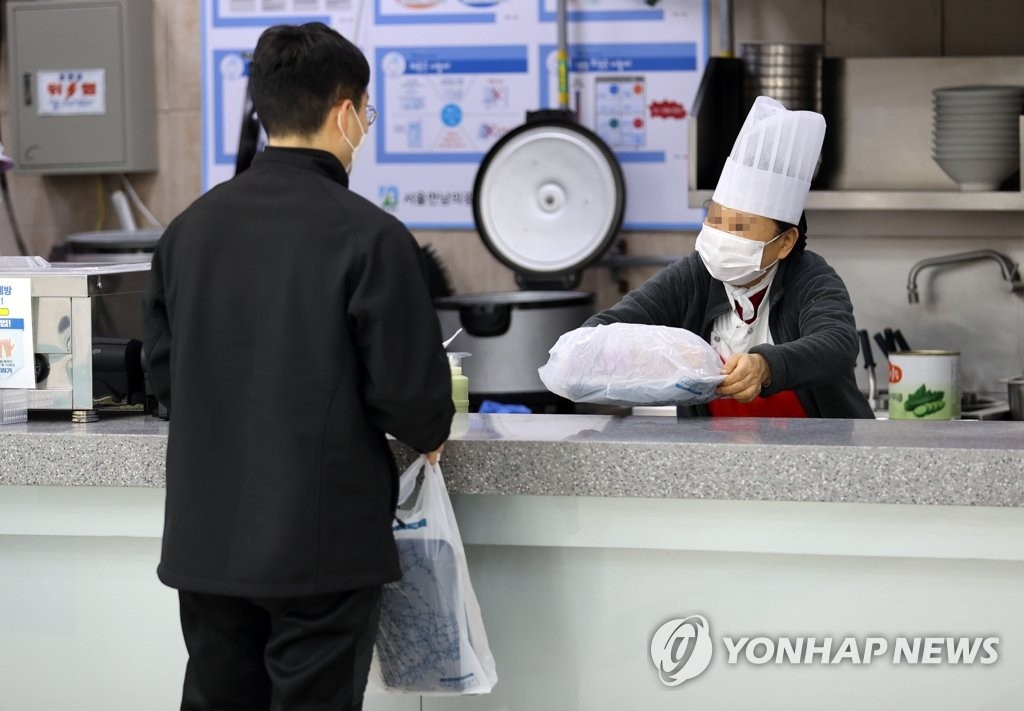 资料图片：2月10日，在首尔一高速公路服务区，一名市民买打包便当。 韩联社