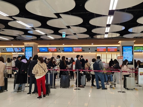 2月10日，在金浦机场，旅客们排队等候值机。 韩联社