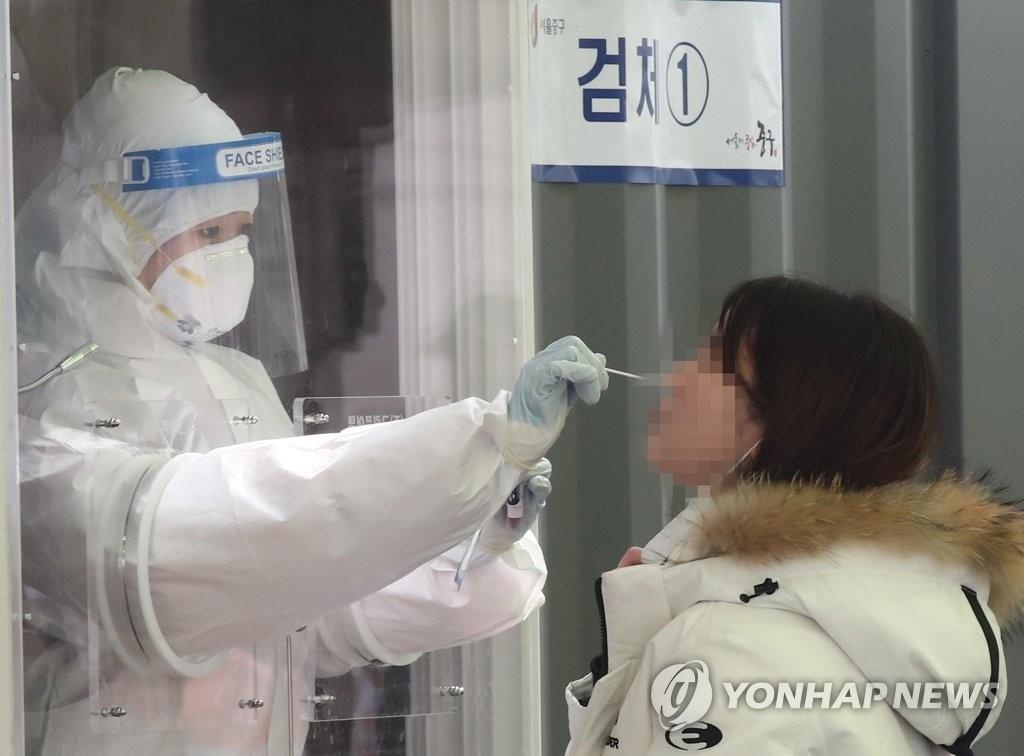 资料图片：在一处筛查诊所，一名市民接受新冠病毒检测。 韩联社