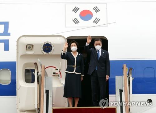 6月11日，在京畿道首尔机场，韩国总统文在寅（右）和夫人金正淑在空军一号上向送行人群挥手致意。 韩联社