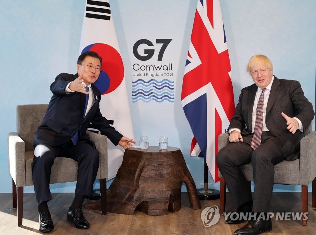 当地时间6月13日，在英国康沃尔卡比斯贝，韩国总统文在寅（左）同英国首相鲍里斯·约翰逊举行会谈。 韩联社