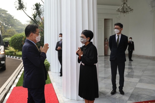 6月25日，在印尼雅加达，韩国外长郑义溶（左）和印尼外长蕾特诺·马尔苏迪互致问候。 韩国驻印尼大使馆供图（图片严禁转载复制）