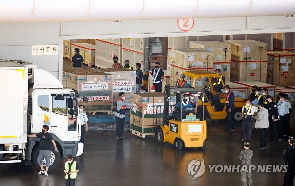 7月8日下午，韩国政府采购的莫德纳新冠疫苗中35.4万剂运抵仁川国际机场。图为工作人员卸货。 韩联社