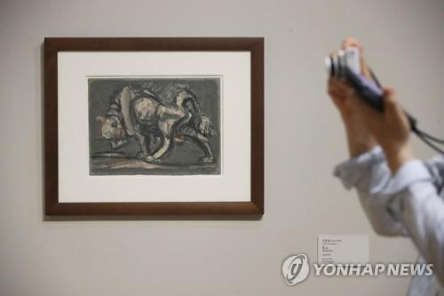 7月20日，在首尔市钟路区的国立现代美术馆首尔馆，“李健熙藏品特展——韩国美术名作”媒体见面会举行。图为参会者观赏李仲燮的作品《黄牛》。 韩联社