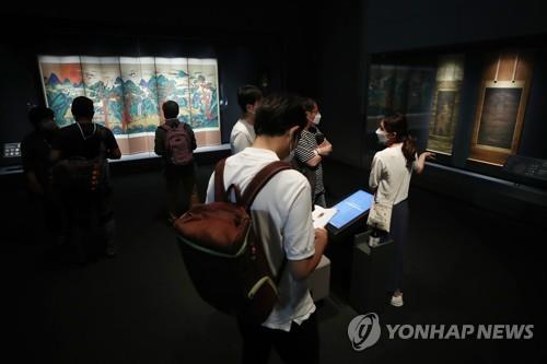 7月20日，在首尔市龙山区的国立中央博物馆，“共享伟大文化遗产——已故李健熙会长捐赠名品展”媒体见面会举行。图为与会人员观看展品。 韩联社