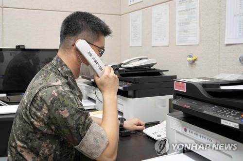 资料图片：7月27日，韩国军方相关人士正通过西海地区军事通信线路与朝军试通话。 韩联社/韩国国防部供图（图片严禁转载复制）