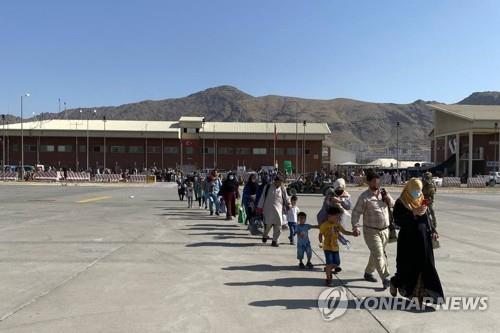 资料图片：8月25日，在阿富汗喀布尔机场，曾为韩国工作过的阿富汗人及其家属准备搭乘韩军运输机。 韩联社/韩国外交部供图（图片严禁转载复制）
