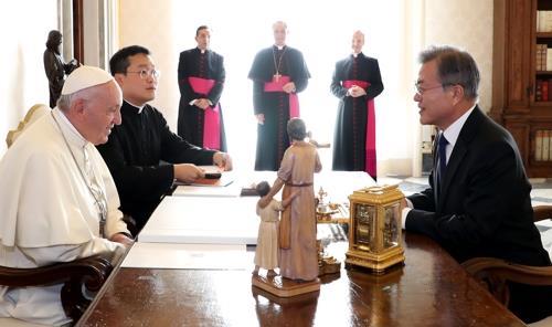 资料图片：当地时间2018年10月18日，在罗马教廷，韩国总统文在寅（右）同教皇方济各交谈。 韩联社