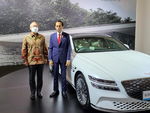 10月25日，在印尼雅加达国际展览中心举行的“未来电动汽车生态系统”活动上，印尼总统佐科·维多多（右）与现代汽车会长郑义宣合影留念。右为现代汽车高端品牌捷尼赛思G80电动版。 韩联社