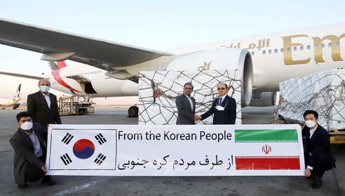 当地时间10月27日，韩国政府向伊朗援助的100万剂阿斯利康新冠疫苗抵达德黑兰伊玛目·霍梅尼国际机场。图为韩国驻伊朗大使尹焵铉（右二）和伊朗卫生部人士合影留念。 韩联社